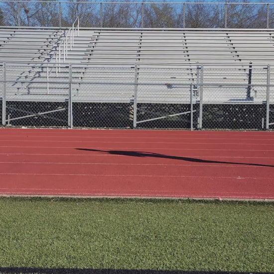 Video of a high school athlete during gait capture, side view of them running on the track.